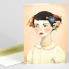 A folded greeting card featuring an illustration of a girl with short dark hair wearing a polka-dot collared shirt and a flower crown of pansies and other blossoms.