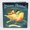A hardcover book titled "Dream Animals" with the subtitle "A Bedtime Journey," featuring an illustration of two children riding a large bird and the author name "Emily Winfield Martin."