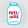 A white chenille patch shaped like a jar or bottle with teal embroidered outline details and red embroidered text reading "FEEL-INGS".