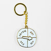 A gold-tone keychain with a round white enamel-style charm divided into four sections labeled "MAYBE," "IDK," "YES," and "NO," with a white arrow in the center.