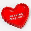 A glossy red heart-shaped ceramic tray with scalloped edges and the white text "NOTHING MATTERS" on the top.