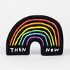 A black chenille patch shaped like a rainbow arch with embroidered rainbow stripes and the words "THEN" and "NOW" in white at the bottom.
