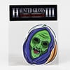 A clear sticker pack with a black header reading "HAUNTED GRAVES III" and "SEASON OF THE STICKER," showing a large illustrated green skull-like face wrapped in purple cloth with orange accents.