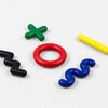 Five small crayons in the shapes of a green plus sign, red ring, yellow bar, black zigzag, and blue wavy line.