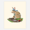 An illustrated print of a rabbit wearing a blue hat and apron, sitting in a small garden patch with seedlings, a hand trowel, and three small red pots.