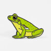 An enamel pin shaped like a bright green frog with a yellow underside, black outline, and large round eye, shown in a sitting pose.
