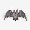 A gray enamel pin shaped like a bat with outstretched wings and pink inner ears.