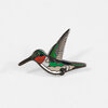 A hummingbird-shaped enamel pin with a long beak, green and brown wings, red chest markings, and black metal outlining.