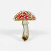 A mushroom-shaped enamel pin with a red cap covered in white spots, a cream-colored stem, and gold-tone outlines.