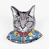 A cat-shaped enamel pin featuring a gray cat with yellow eyes wearing a colorful punk-style jacket and red collar.