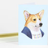 A folded greeting card featuring an illustrated corgi wearing a shirt with the text "YOU'RE SIMPLY THE BEST" on the front.