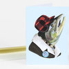 A folded greeting card shows a salmon wearing a red-and-black plaid cap and jacket with a round badge that reads "BEST DAD JOKES."