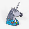 A metal enamel pin shaped like a unicorn head in profile, with a gray mane, pale horn, and bright blue jacket decorated with rainbow and candy-like details.