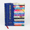 A blue hardcover book titled "BIBLIOPHILE" with gold lettering and a vertical stack of colorful book spines illustrated on the cover, reading "An Illustrated Miscellany by Jane Mount."