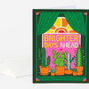 A folded greeting card with a dark green border shows a window framed by green curtains, a sunrise, potted cacti and succulents, and the text "BRIGHTER DAYS AHEAD."