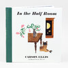 A hardcover book titled "In the Half Room" by Carson Ellis with a green spine, white front cover, and an illustration of a table, vase, window, and cat.