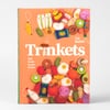 A hardcover book with an orange cover showing many small felt food trinkets and the title text "Cat Rabbit Trinkets" with the subtitle "Felt foods to sew & love".