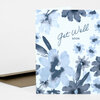 A folded greeting card with a blue-gray floral pattern and the text "Get Well Soon" on the front, shown with a plain brown envelope partially visible behind it.