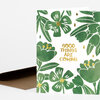 A folded greeting card with a green floral pattern and gold foil text that reads "GOOD THINGS ARE COMING."