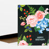 A folded greeting card with a black front covered in colorful floral illustrations and the text “HAPPY BIRTHDAY” in white.