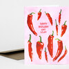 A folded greeting card with a pink cover printed with red chili peppers and the text "HAPPY BIRTHDAY HOT STUFF" in the center.