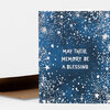 A folded greeting card with a dark blue cover covered in white starry speckles and the text "MAY THEIR MEMORY BE A BLESSING" in the center.