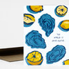 A folded greeting card with blue and yellow oyster illustrations and the text "THE WORLD IS YOUR OYSTER" on the front.