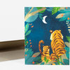 A folded greeting card with an illustrated cover showing two tigers sitting in leafy jungle foliage under a crescent moon.