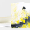 A folded blank greeting card with an illustration of a person in yellow rain boots holding a watering can among yellow flowers and plants.
