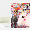 A folded greeting card featuring a colorful illustration of a large tree and a child reaching up toward the branches.