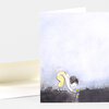 A folded greeting card with an illustrated child bending over to pick up a small yellow heart near the bottom edge, with no visible text on the front.