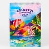 A spiral-bound calendar cover with the text "COLORFUL LANDSCAPES 2027" and "by DURIDO," featuring bright multicolored abstract mountain and water scenes.