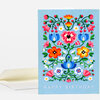A blue greeting card with a colorful symmetrical floral design and the words "HAPPY BIRTHDAY" printed at the bottom, shown with a matching envelope.