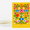 A yellow greeting card with a symmetrical floral illustration and the words "HAPPY BIRTHDAY" on the front, shown with a matching white envelope.