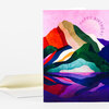 A folded greeting card with a colorful abstract mountain-and-lake illustration and the words "HAPPY BIRTHDAY" arched near the top.