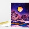 A folded greeting card with a cover illustration of purple mountain peaks under a starry night sky and a large golden moon.