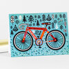 A folded greeting card shows a colorful illustrated bicycle with the text "GREAT MINDS RIDE A BIKE," "IF YOU REST YOU RUST," and "ADVENTURE," surrounded by stylized trees and mountains.
