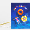 A folded greeting card with the words "HAPPY BIRTHDAY" arched across the top and illustrated pool float rings and swimmers in blue water.