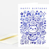 A folded greeting card with the words "HAPPY BIRTHDAY" and a blue illustrated design of cats, flowers, and decorative shapes, plus an "I ♥" cat graphic near the bottom.