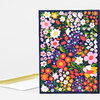 A folded greeting card with a dark navy front covered in a dense multicolored floral pattern and a white envelope.