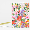 A folded greeting card with a tan cover covered in a dense multicolored floral pattern of stylized flowers, leaves, and vines.