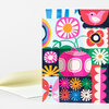 A folded greeting card with a colorful patchwork-style design featuring flowers, a butterfly, a bird, and geometric shapes.