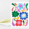 A folded greeting card with a colorful abstract floral design featuring large blue, green, red, and purple flowers and wavy decorative shapes on a white front.