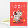 A red greeting card featuring the text "HAVE AN ACE BIRTHDAY!" above a cartoon cat holding a tennis racket with tennis balls around it.