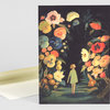A greeting card with an illustration of a small girl standing in a dark flower garden surrounded by large colorful flowers.