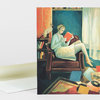 A greeting card featuring an illustration of a woman in a chair reading a red book with a cat perched behind her and books scattered around the room.