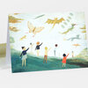 A folded greeting card shows an illustration of several people flying whimsical animal-shaped kites, including a butterfly, dragon, bat, tiger, and other creatures.