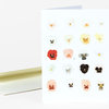 A folded greeting card featuring a grid of small pansy flower illustrations in white, yellow, red, pink, black, and gray tones on a white front.