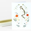 A folded greeting card featuring a watercolor illustration of a nude woman surrounded by flowers and leaves.