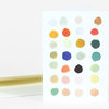 A folded greeting card with a front covered in a grid of colorful painted dots and a plain matching envelope behind it.